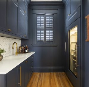 Dark blue cabinetry for butler's pantry with sink, fridge, serving storage