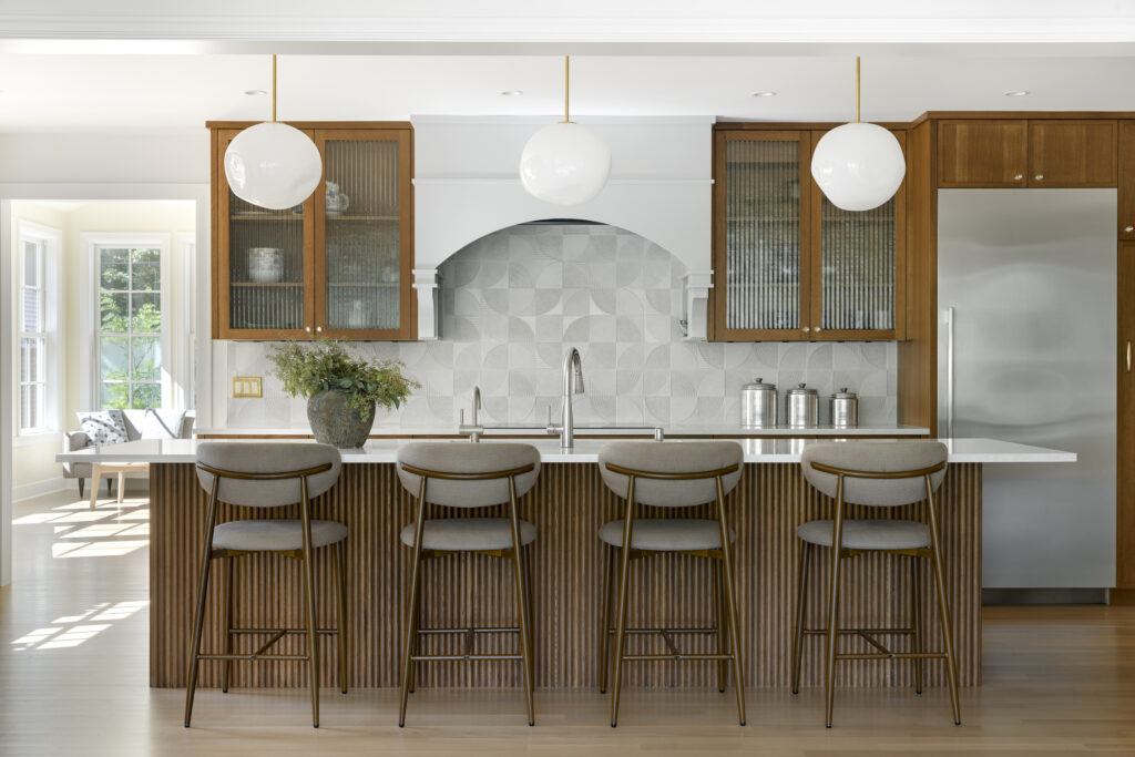 Remodeled Minneapolis kitchen with wood cabinetry, glass cabinet door, circular tile pieces, large island.