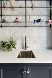 Butler's pantry with glass shelving, bar sink, ovens